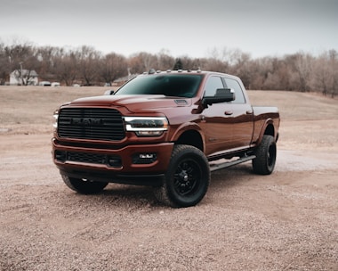 red chevrolet crew cab pickup truck on dirt road during daytime