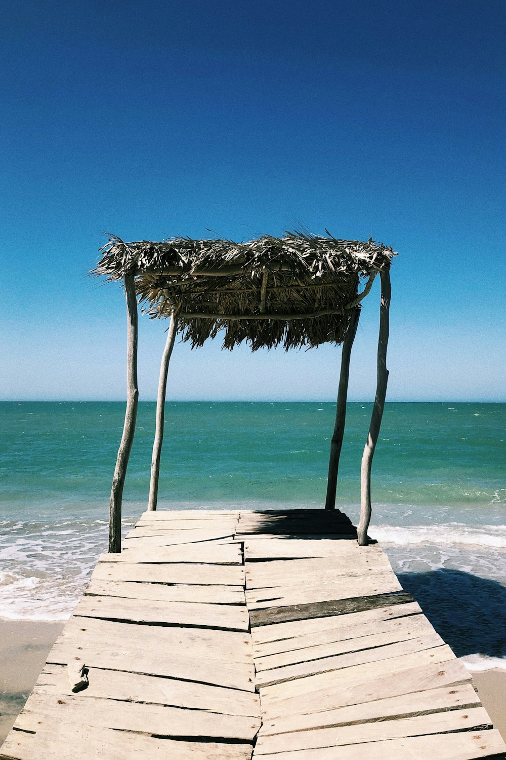 brown wooden beach dock on beach during daytime