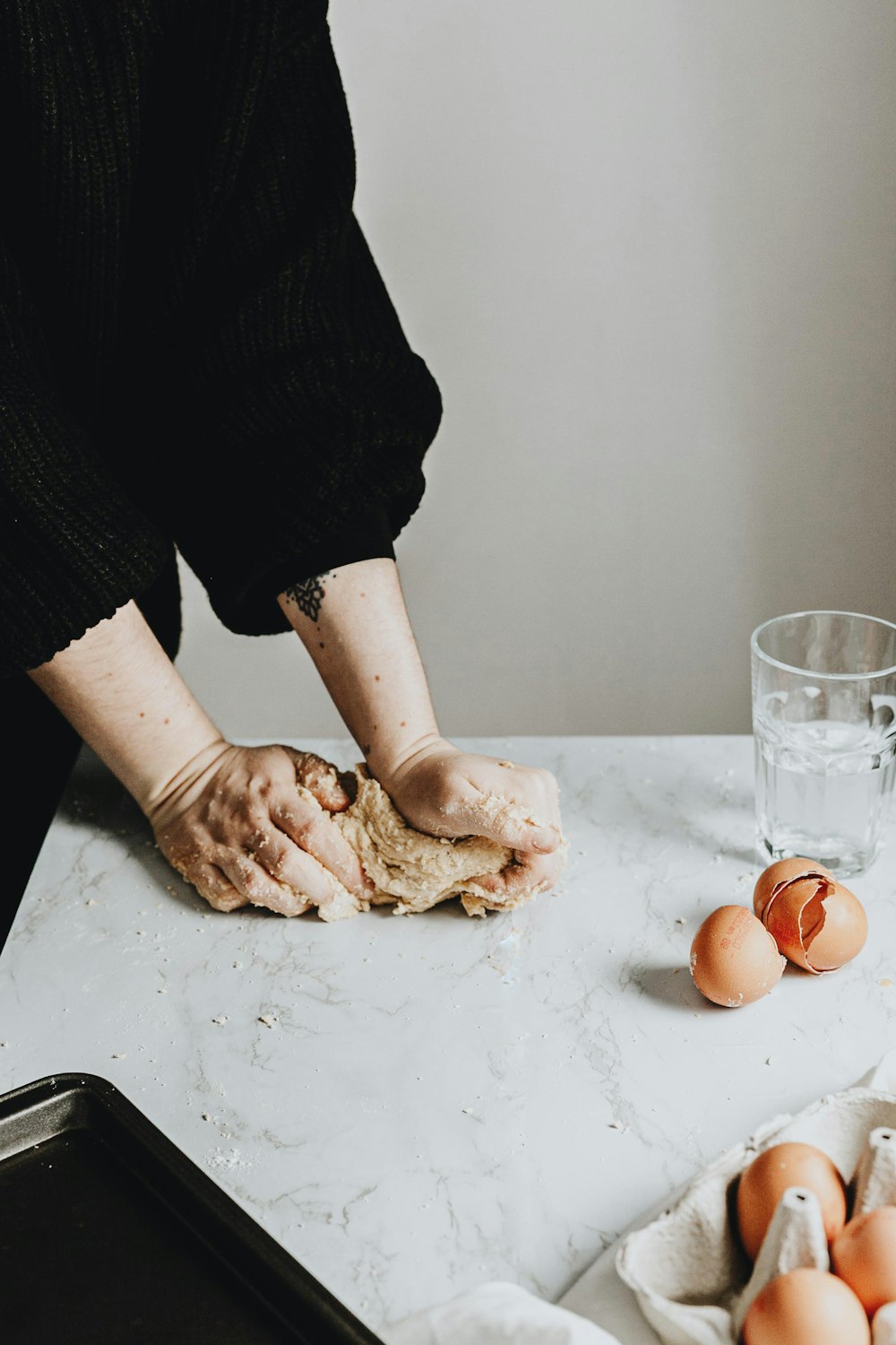 person in black long sleeve shirt holding brown chicken egg