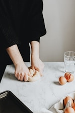 person in black long sleeve shirt holding brown bread
