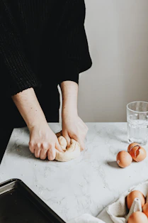 person in black long sleeve shirt holding brown bread