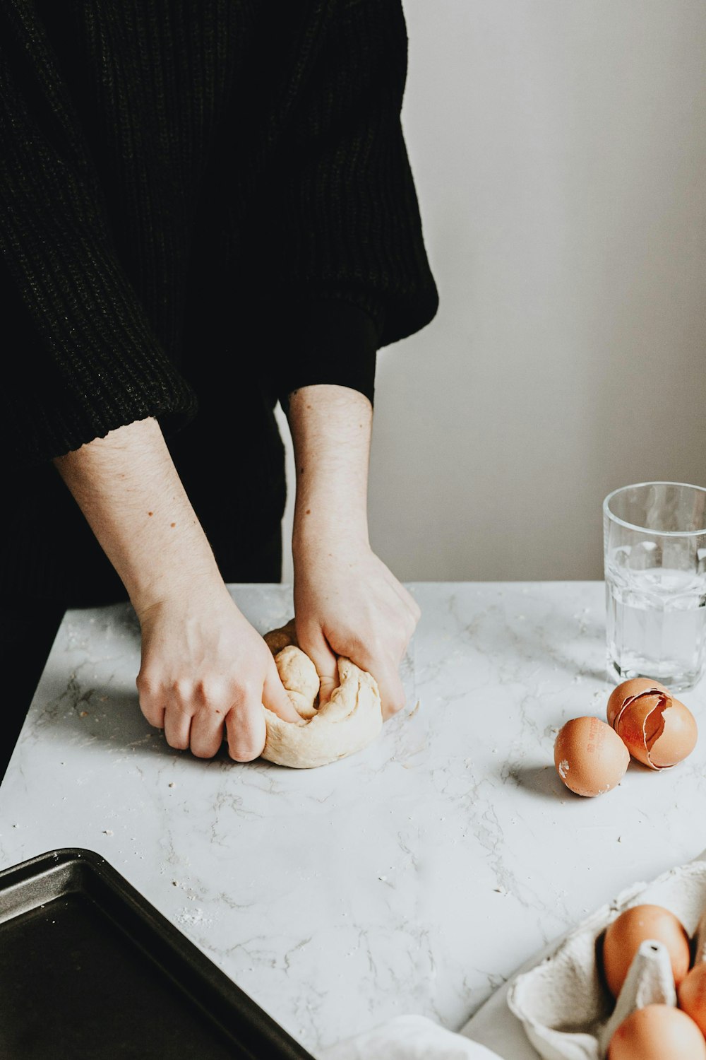 person in black long sleeve shirt holding brown bread