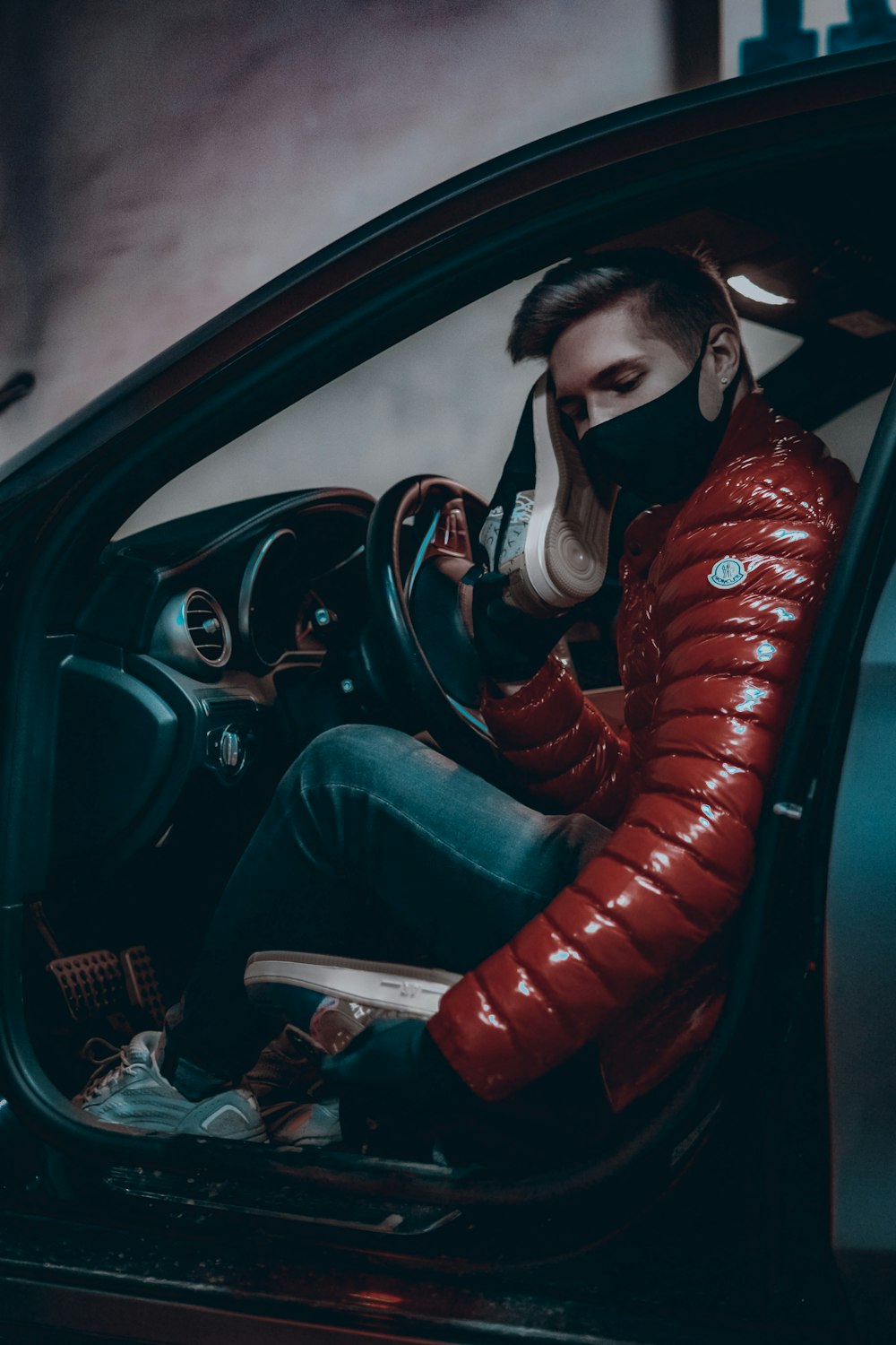 woman in red leather jacket and blue denim jeans sitting on car seat