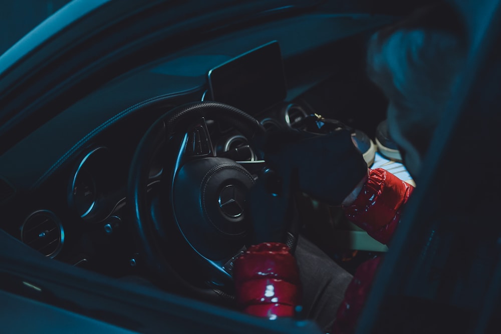 black car steering wheel and red plastic bottle