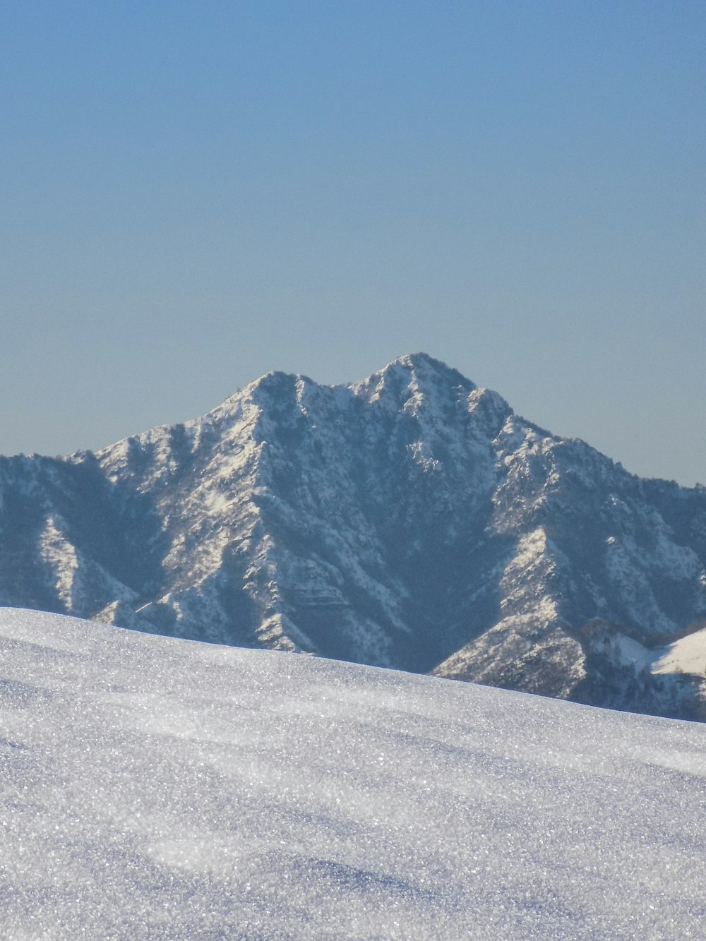 montanha coberta de neve sob o céu azul durante o dia