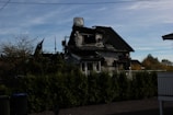 Wide shot of a home exterior showing repaired fire damage under bright daylight.