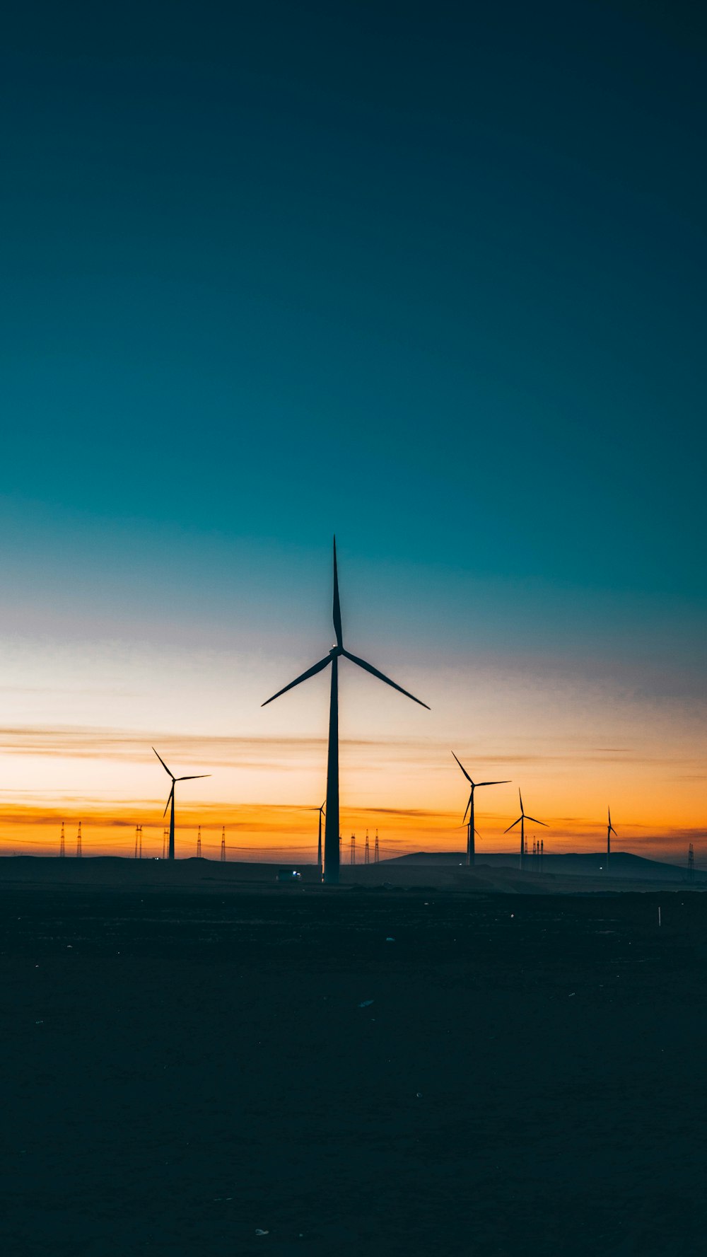 wind turbines under blue sky during sunset