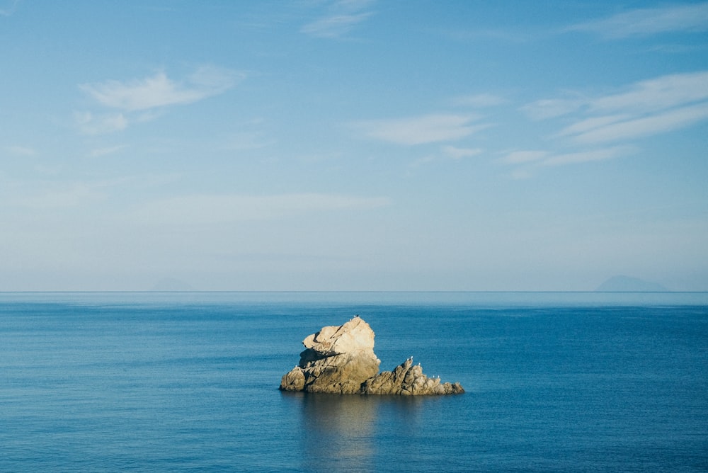 white and brown rock formation on blue sea under blue sky during daytime