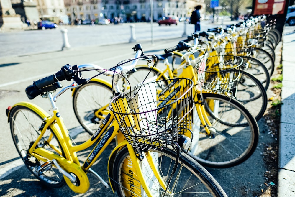 yellow city bikes parked on sidewalk during daytime
