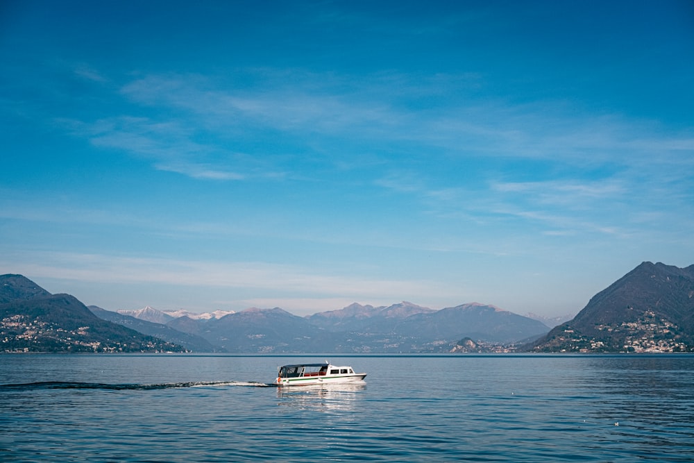 white and blue boat on sea under blue sky during daytime