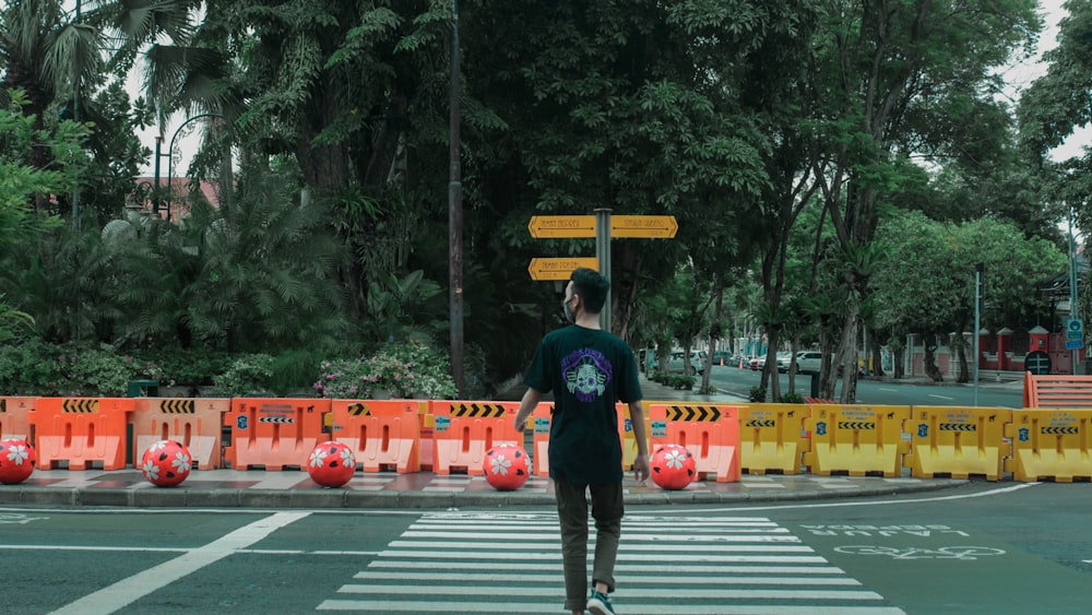 man in black jacket and black pants walking on pedestrian lane during daytime