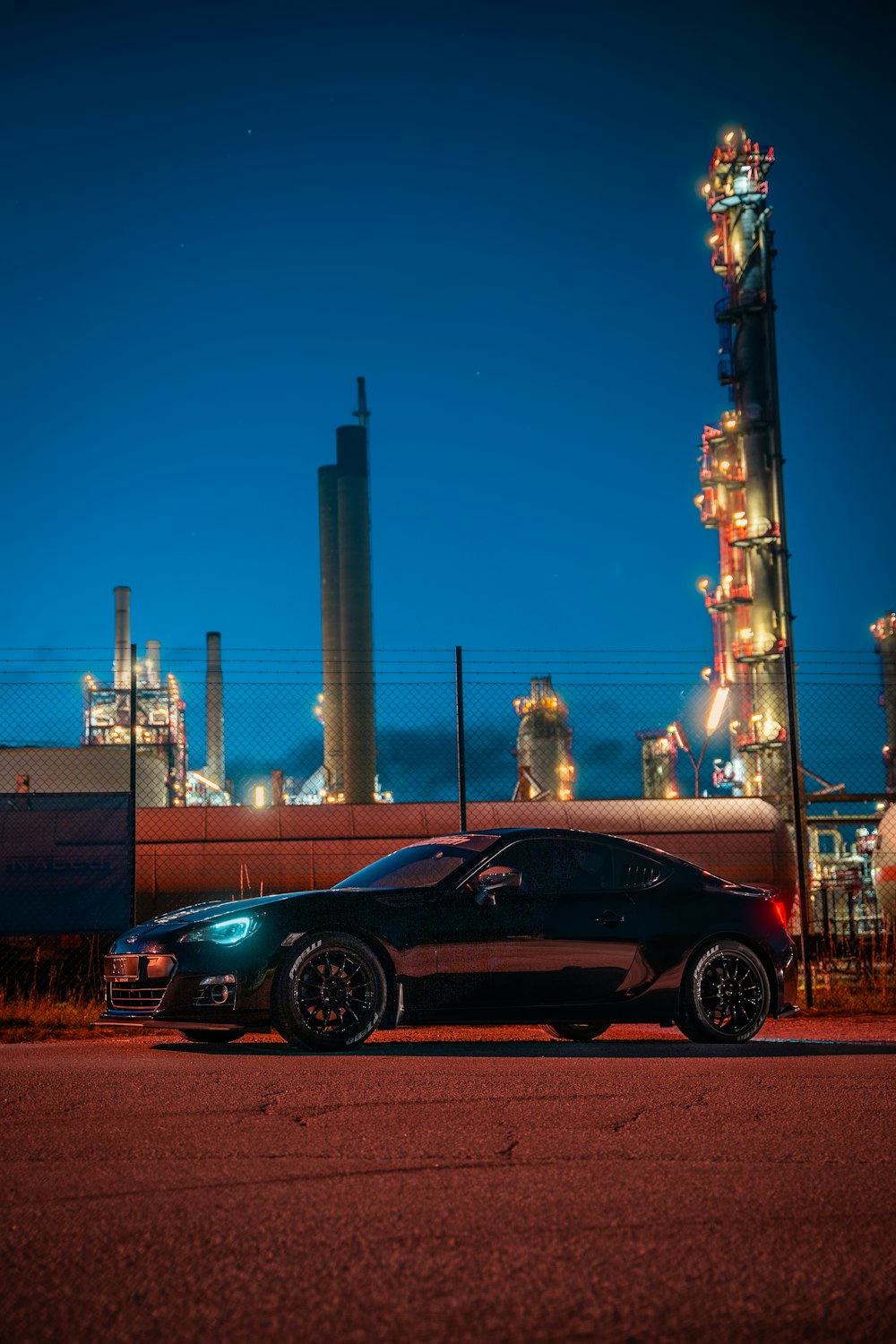 black coupe parked near white tower