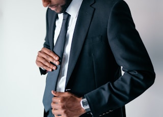 man in black suit holding black smartphone