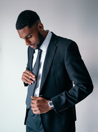 man in black suit holding black smartphone