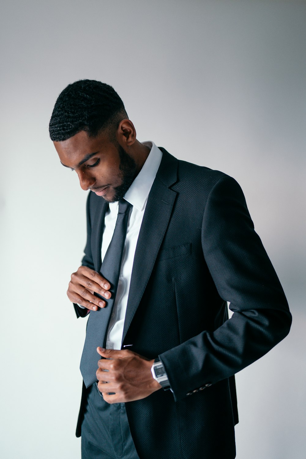 man in black suit holding black smartphone