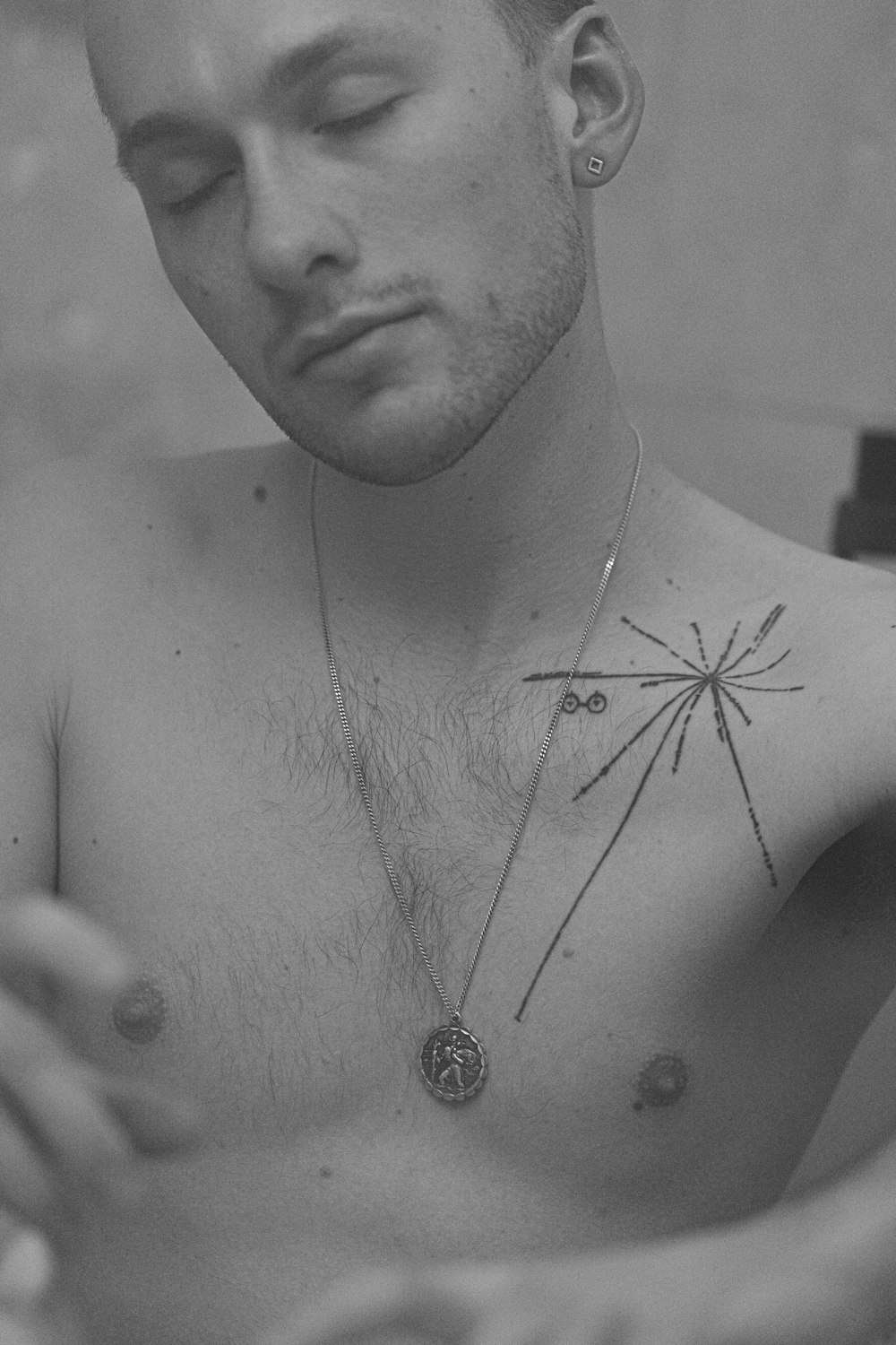 grayscale photo of topless man wearing silver necklace