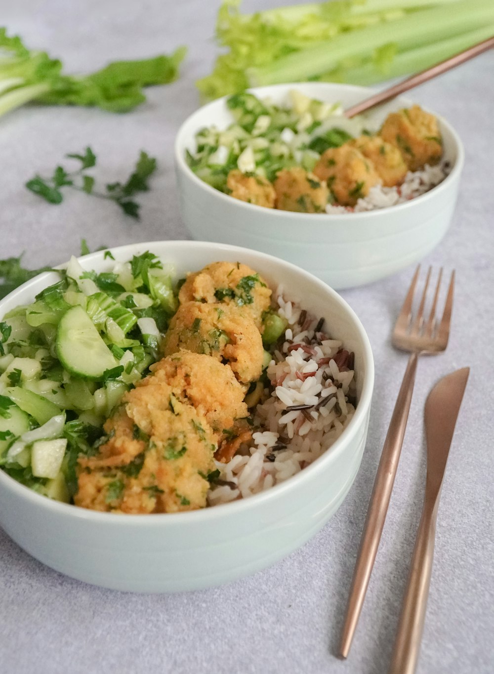 fried rice with sliced cucumber and sliced cucumber in white ceramic bowl