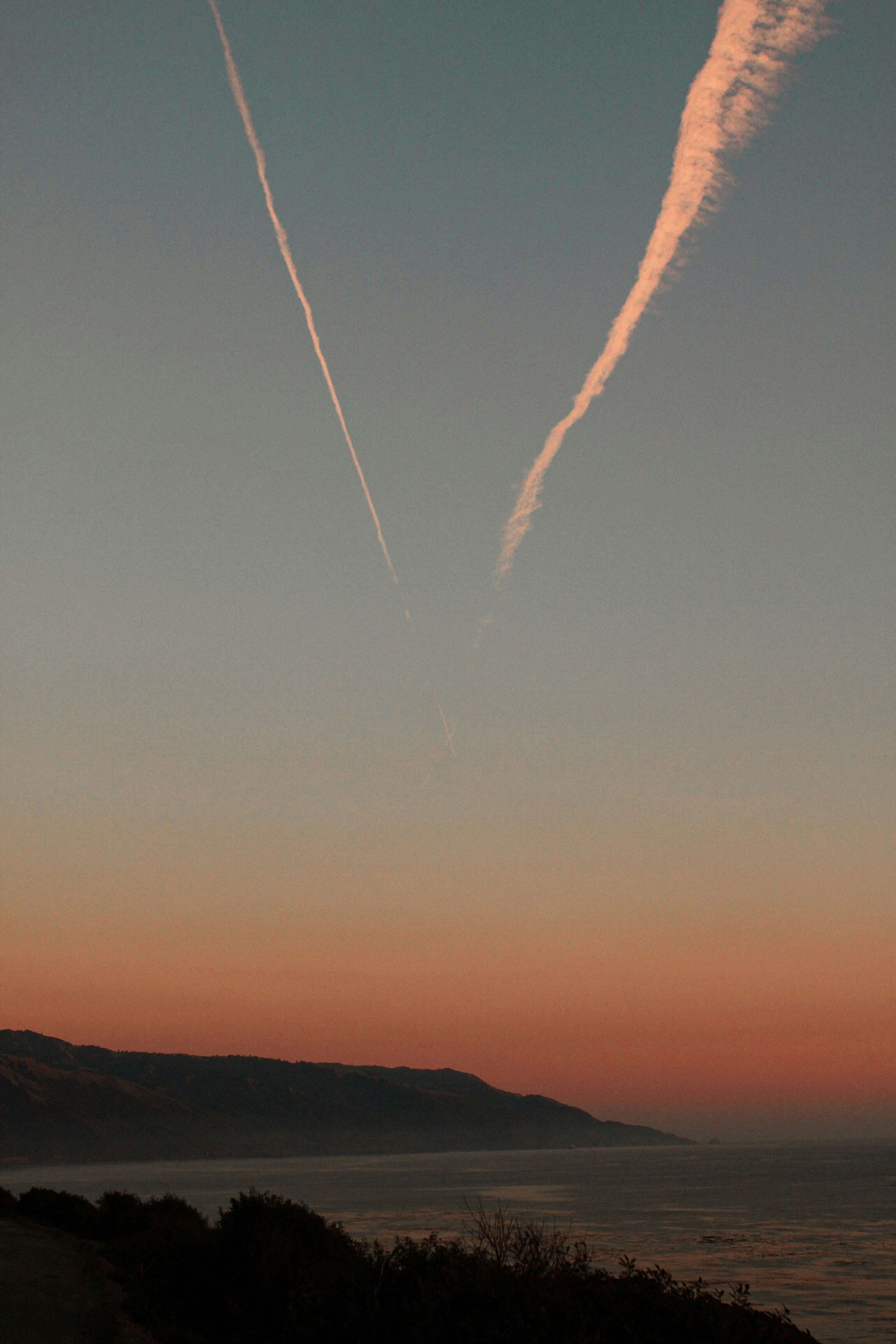 a plane is flying in the sky over the ocean