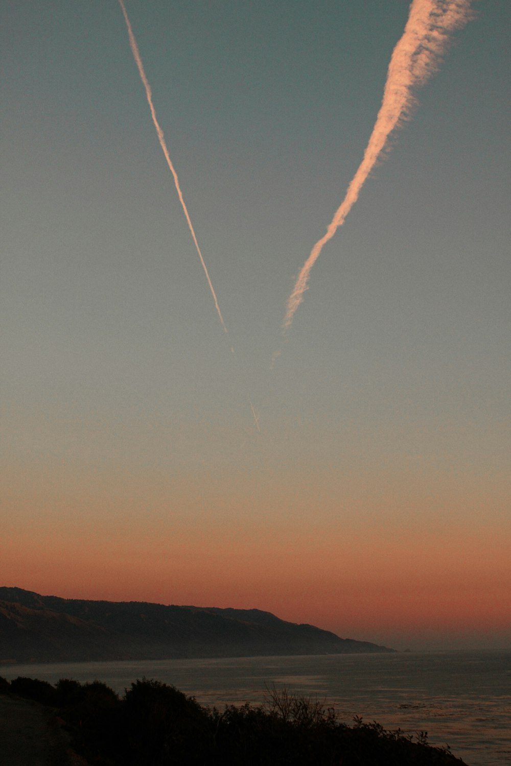 a plane is flying in the sky over the ocean