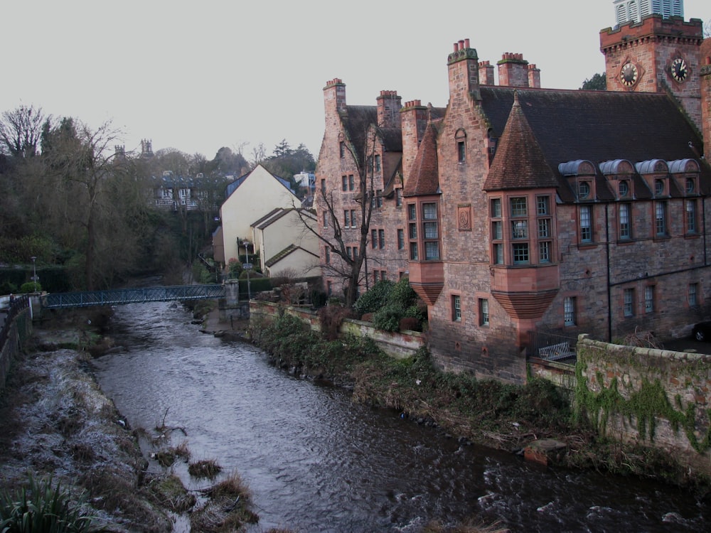 brown concrete building beside river during daytime