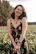 woman in black and red floral spaghetti strap dress smiling