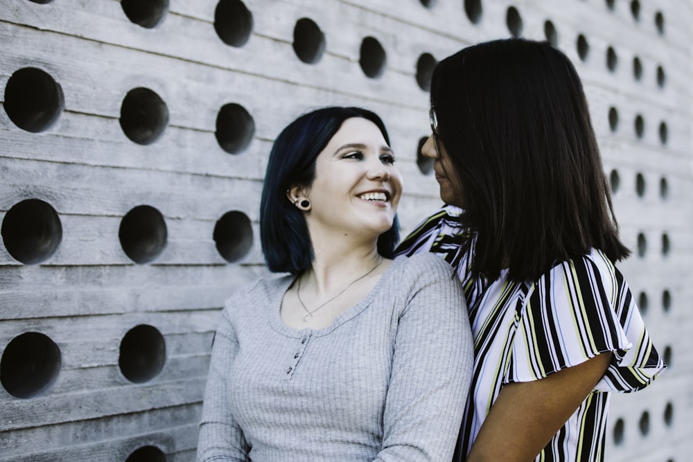 woman in gray sweater beside woman in black and white stripe shirt