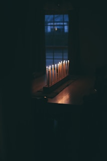 A beautifully lit room with lumé candles on a wooden table, creating a warm ambiance.