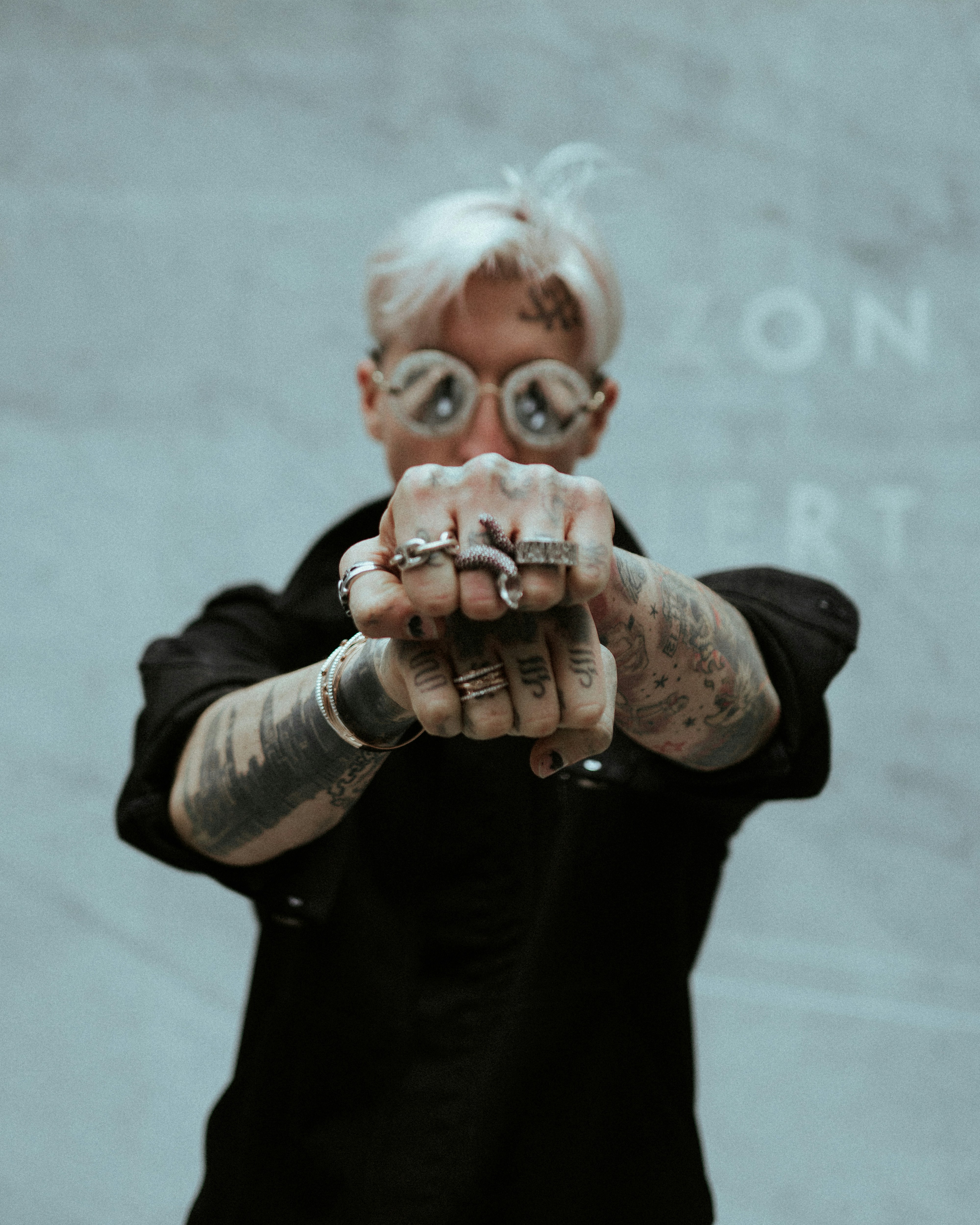 man in black suit jacket holding brown wooden mask