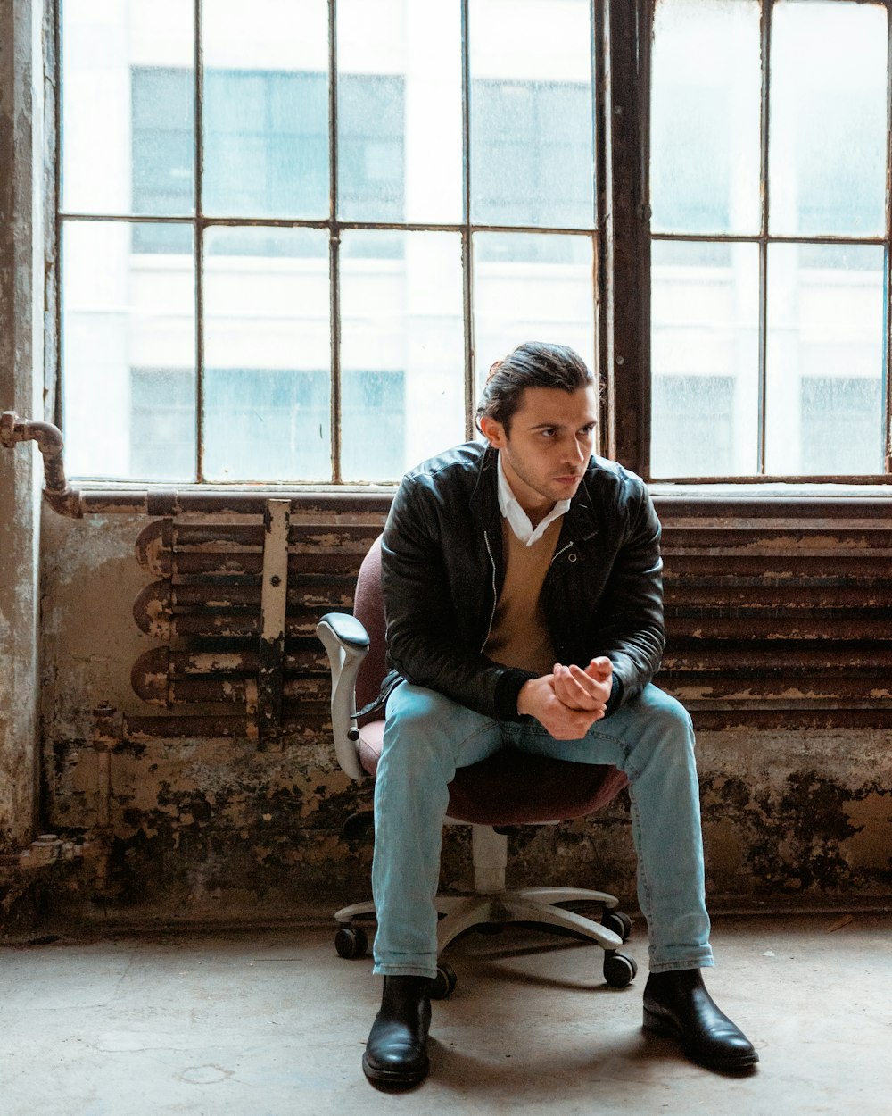 man in black jacket sitting on chair