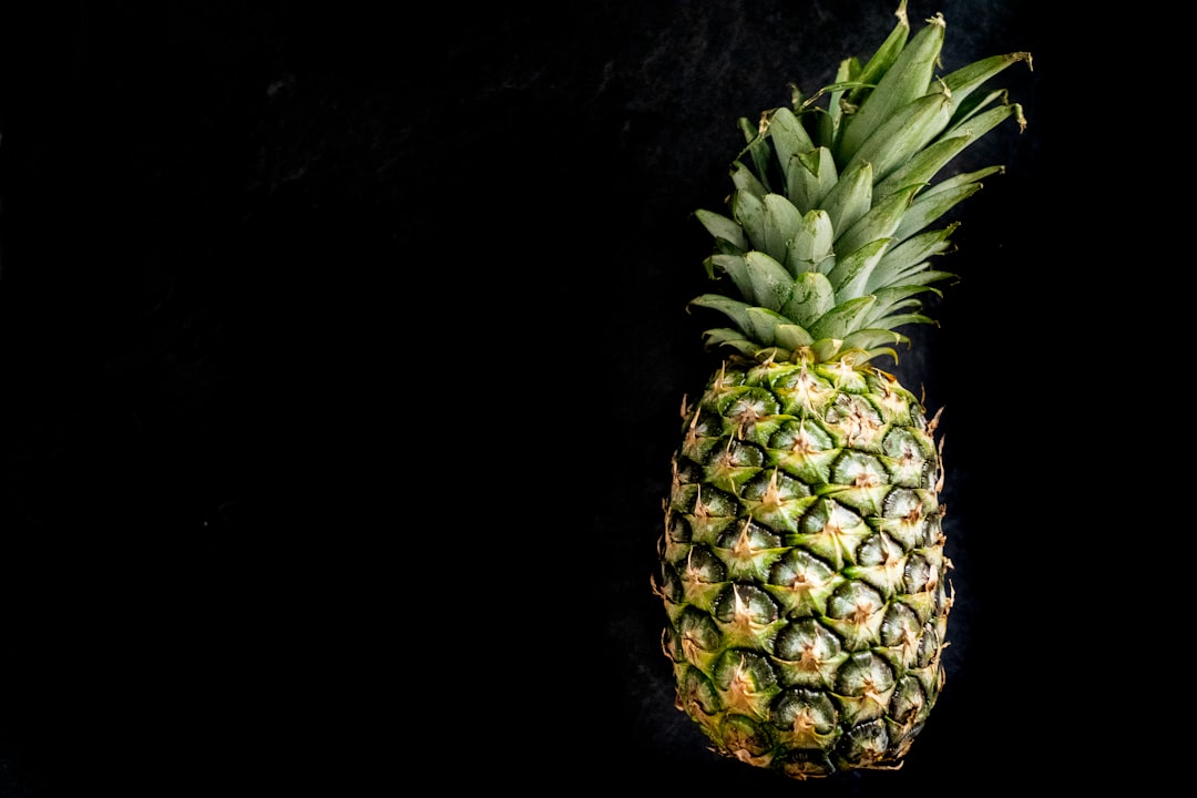 green pineapple fruit on black surface