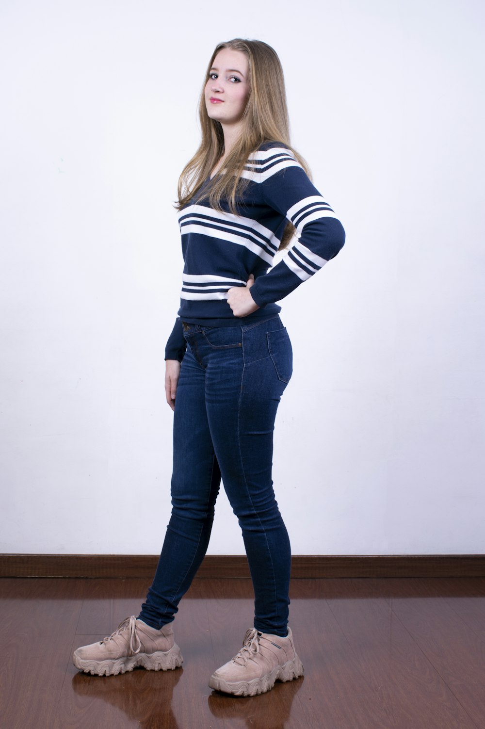 woman in blue denim jeans and white and black striped long sleeve shirt