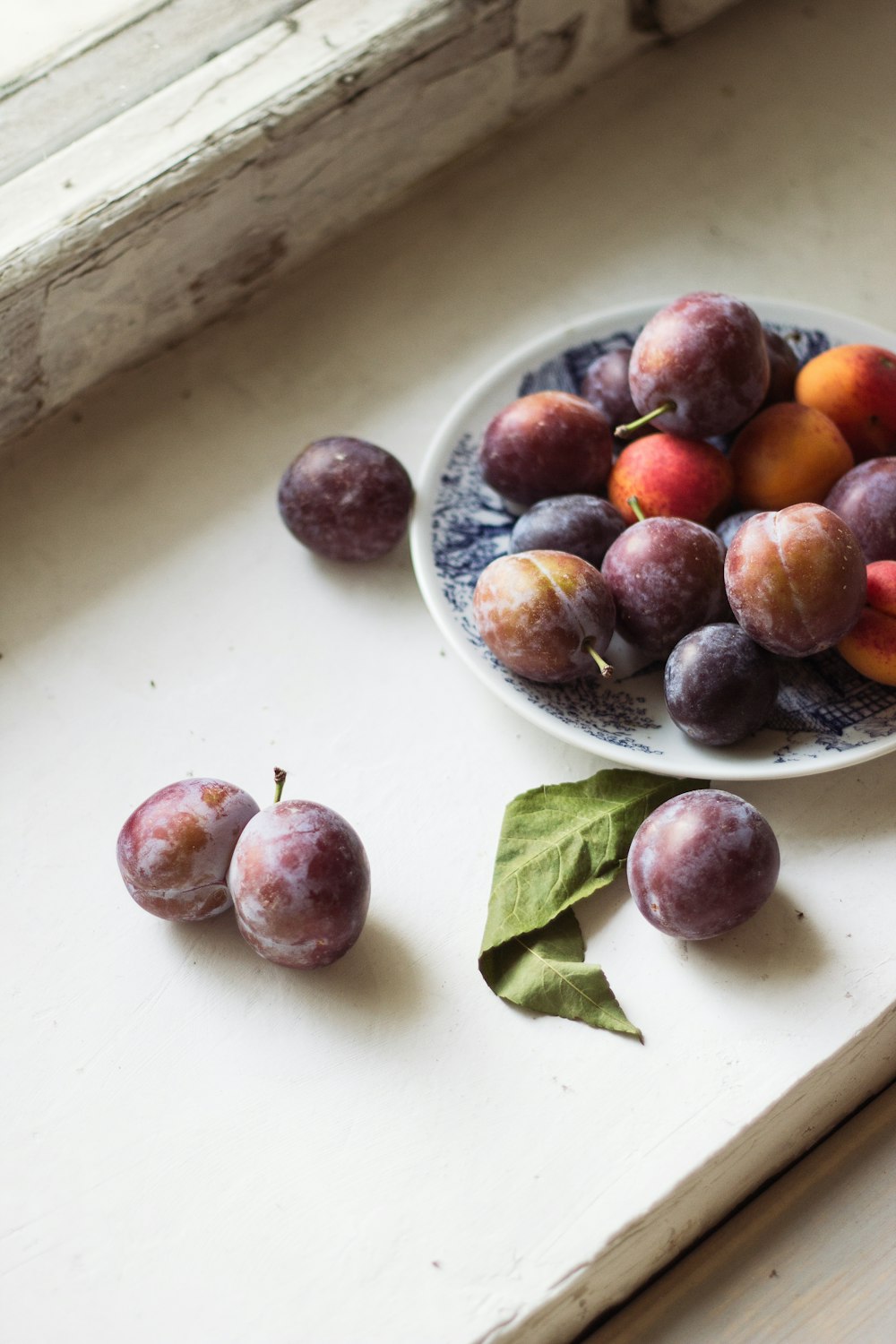 red and purple grapes on white ceramic bowl