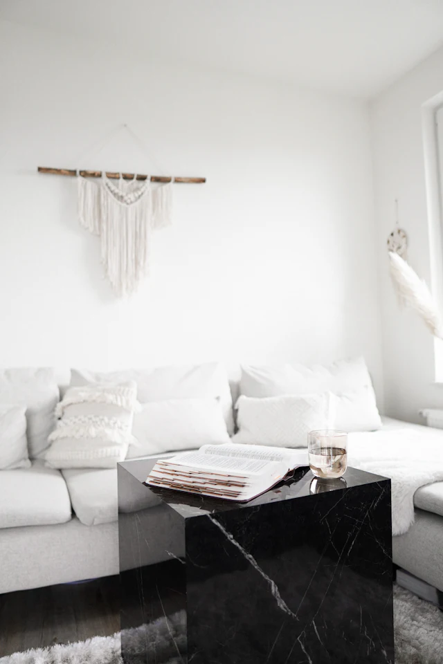 Black wooden table near white sofa