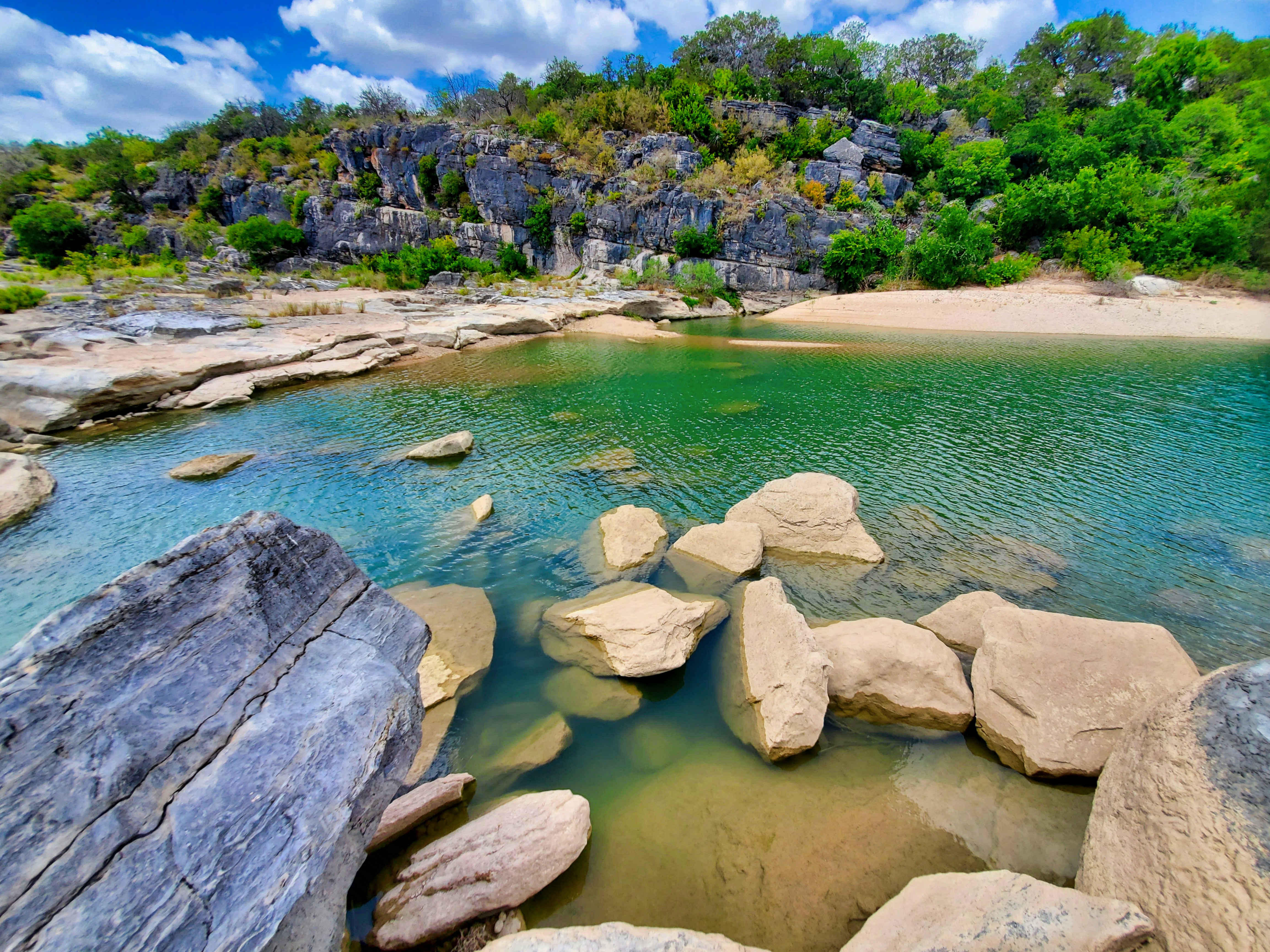 Rochas cinzentas no corpo de água durante o dia