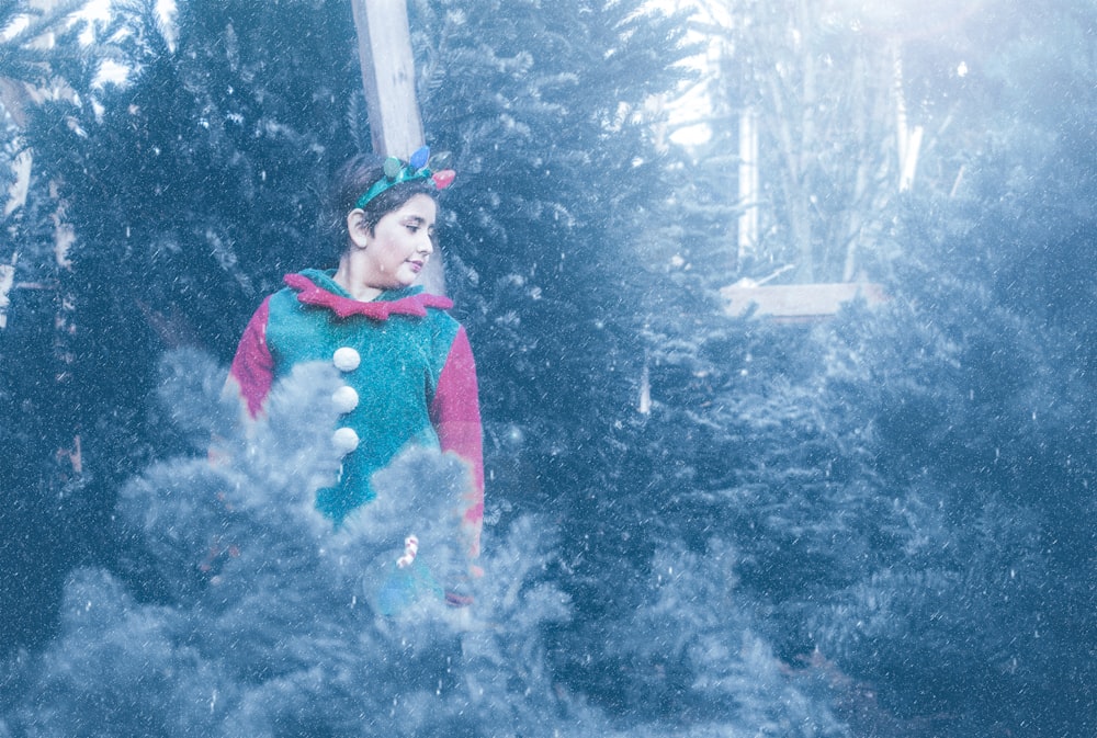 girl in blue and red jacket standing on snow covered ground