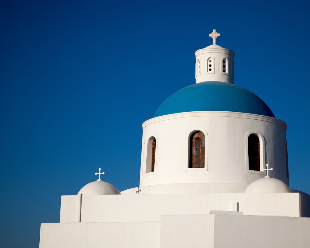 igreja de concreto branco e azul sob o céu azul durante o dia