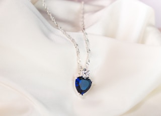 silver necklace with blue gemstone pendant