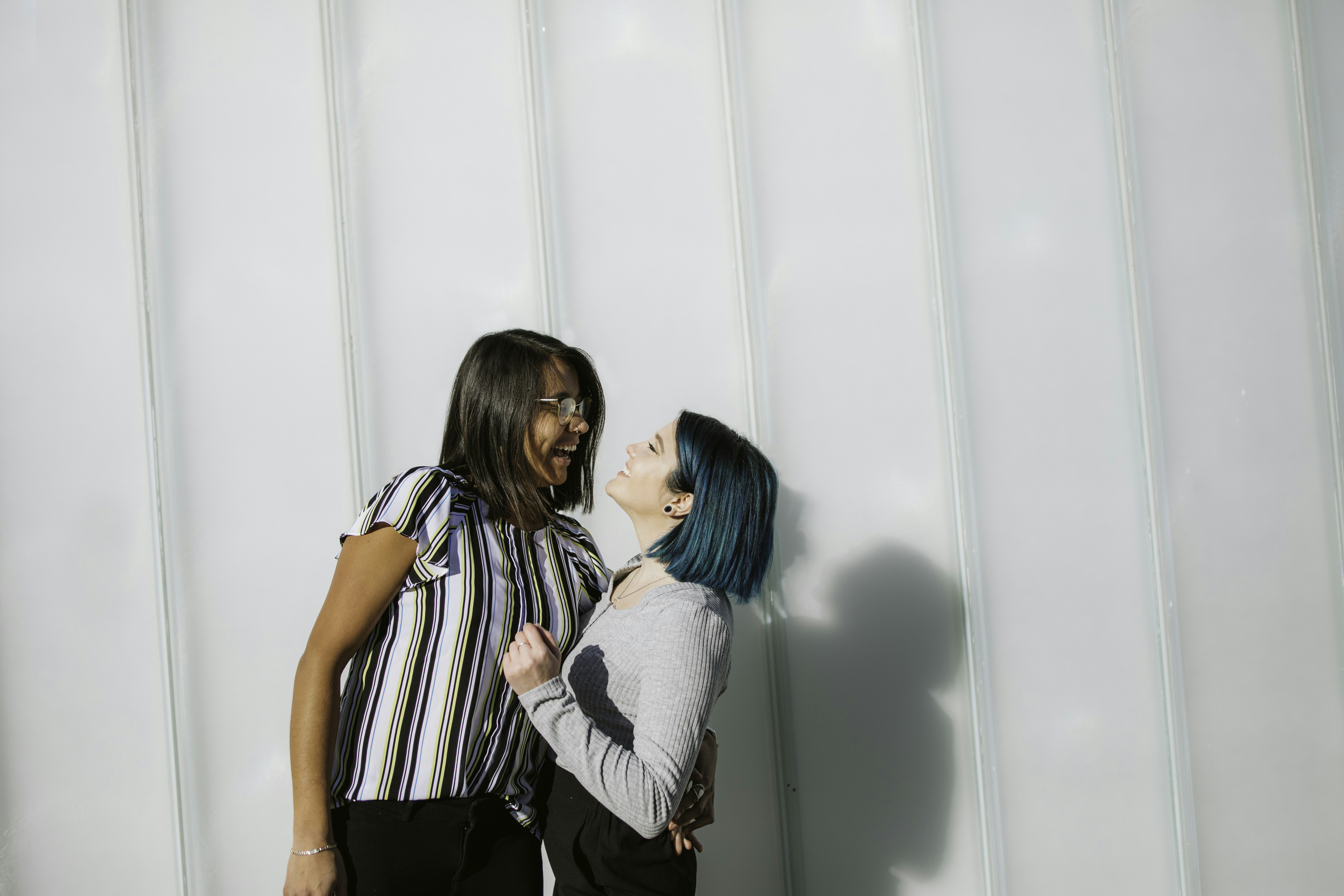 woman in white and black stripe shirt standing beside woman in white long sleeve shirt