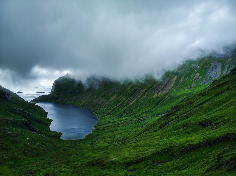 green mountain near body of water during daytime