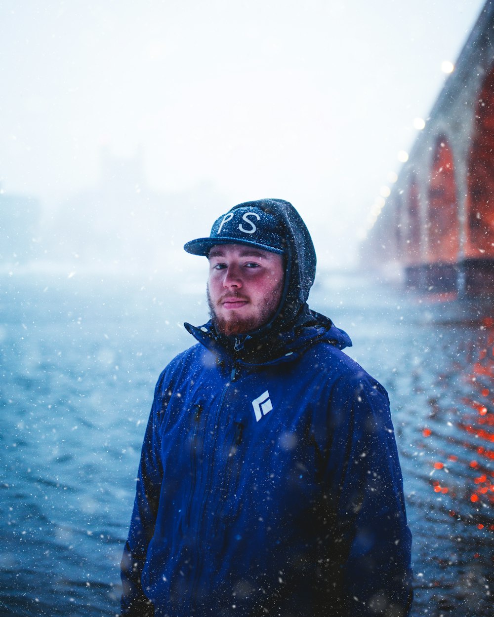 man in blue jacket wearing black cap