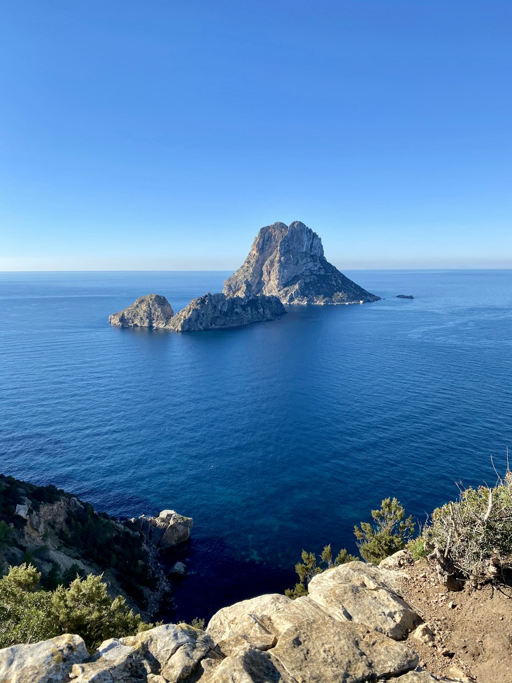 Mer bleue près de la montagne sous le ciel bleu pendant la journée