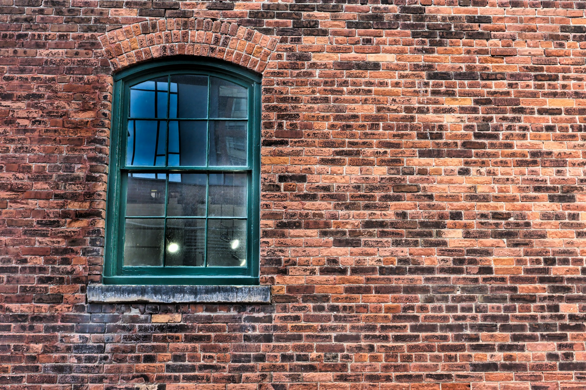 brown brick wall with blue wooden window