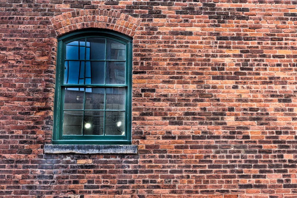 brown brick wall with blue wooden window