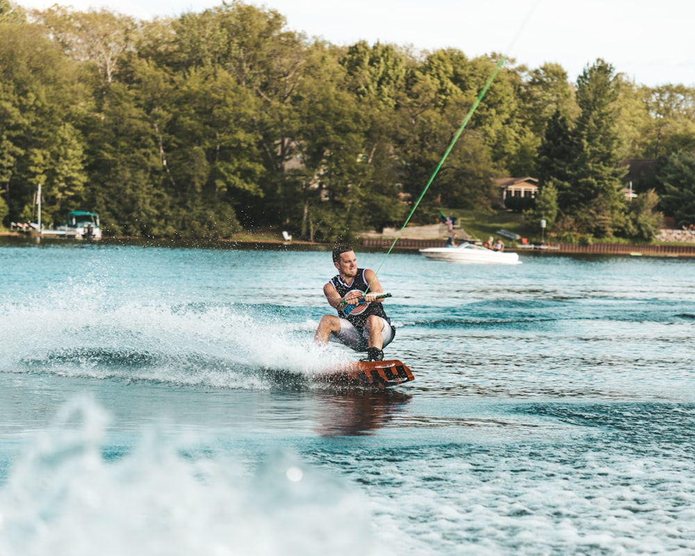 man in red shorts riding red kayak on water during daytime