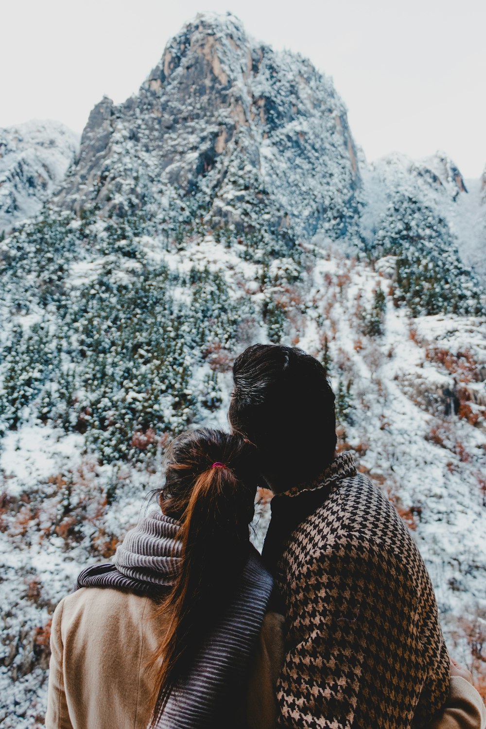 woman in black and white checkered shirt standing on mountain during daytime