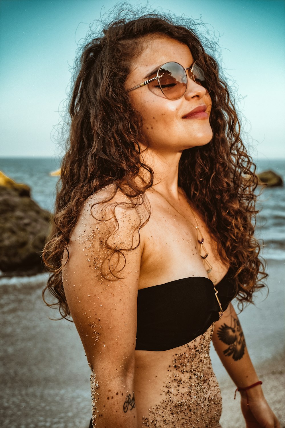 Mujer con sujetador negro y gafas de sol negras