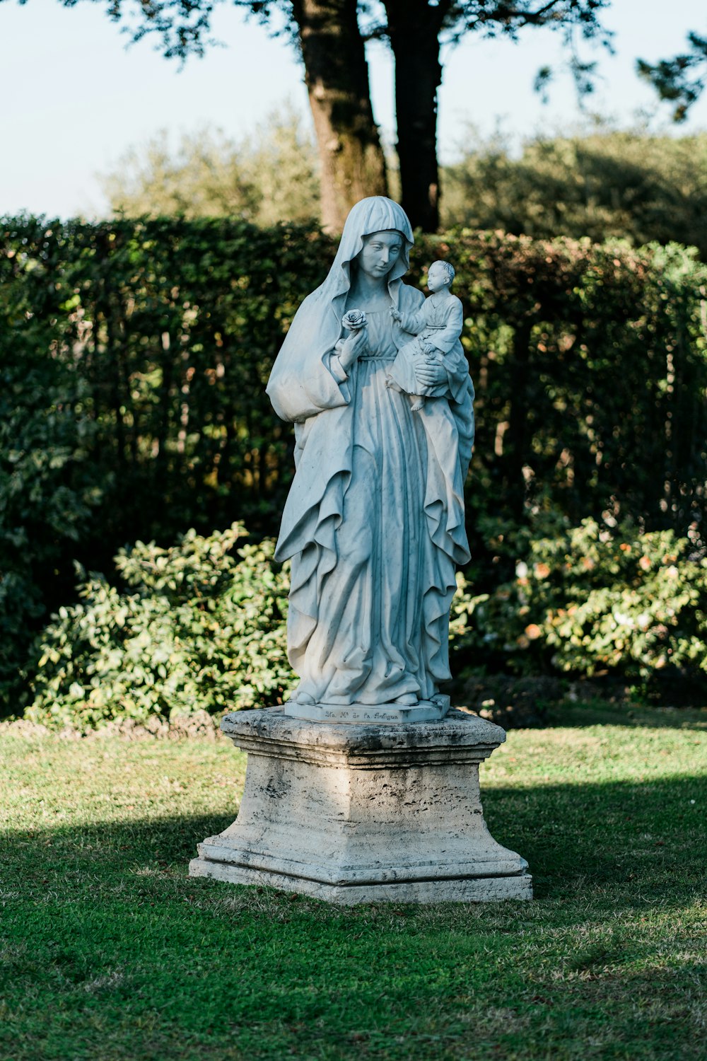 statue d’ange sur le champ d’herbe verte pendant la journée