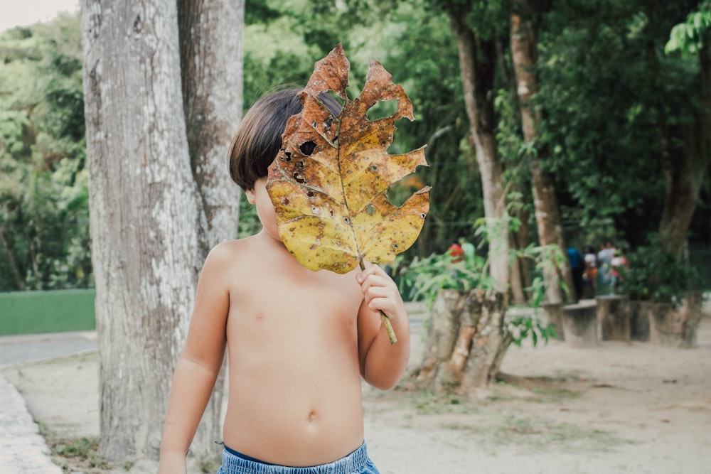 woman in blue denim shorts holding brown leaf