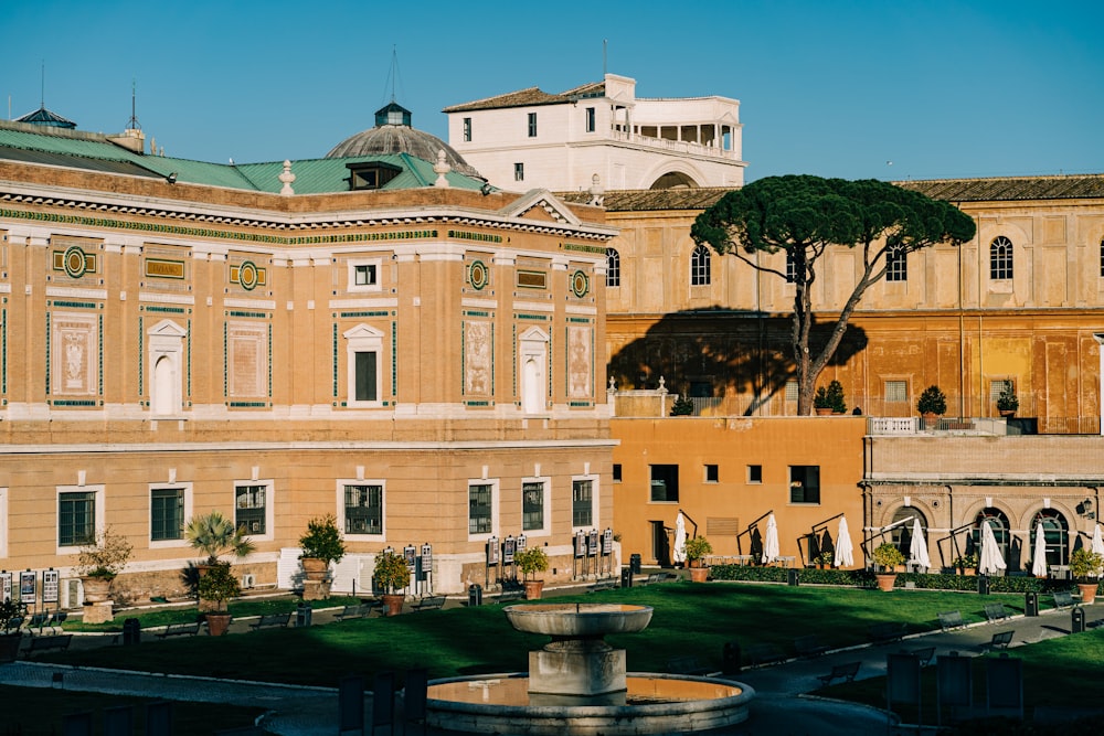 Edificio in cemento beige vicino agli alberi verdi durante il giorno