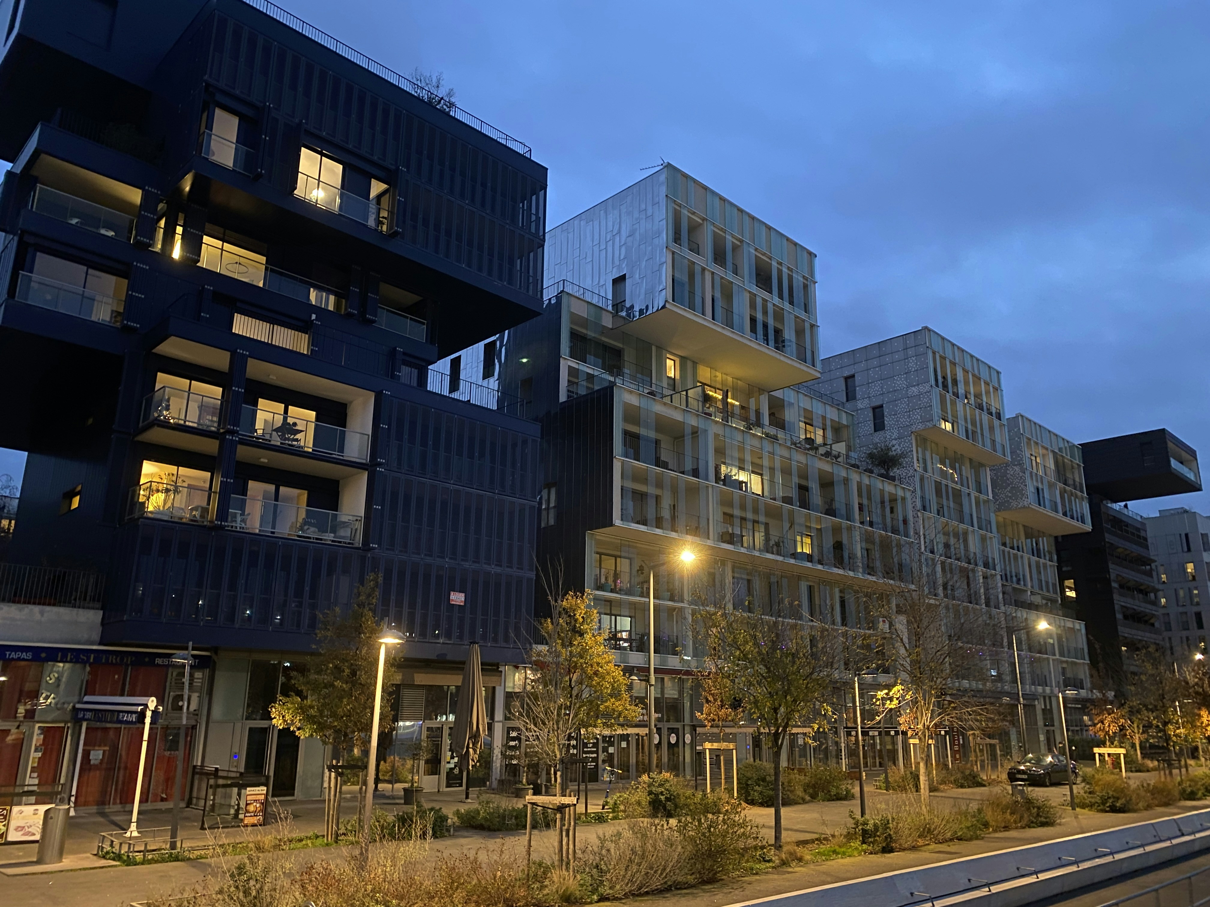 Modern villa facade at dusk, dark moody sky, deep shadows, atmospheric dim lighting